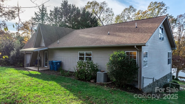 rear view of property featuring a yard and central AC