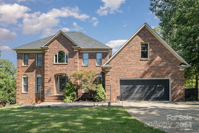 view of front of house with a garage and a front lawn