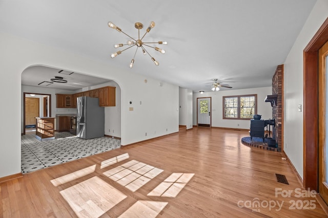 unfurnished living room featuring light hardwood / wood-style floors and ceiling fan with notable chandelier