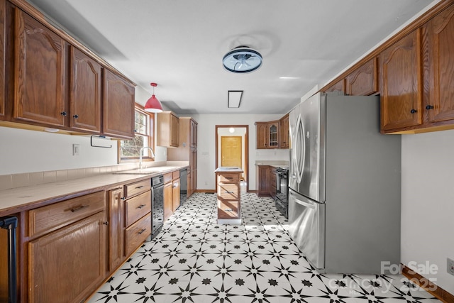 kitchen with hanging light fixtures, sink, and stainless steel appliances