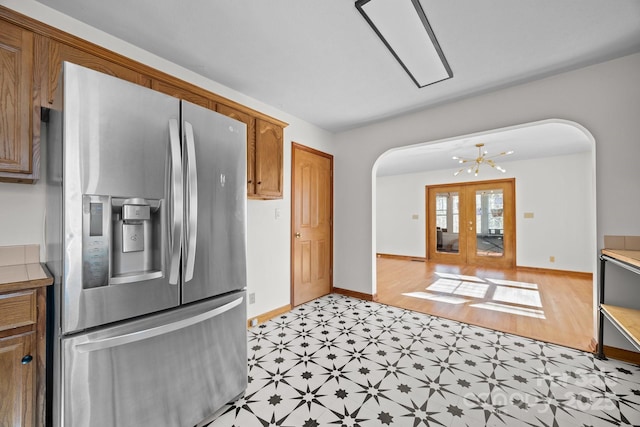 kitchen with stainless steel fridge and a chandelier