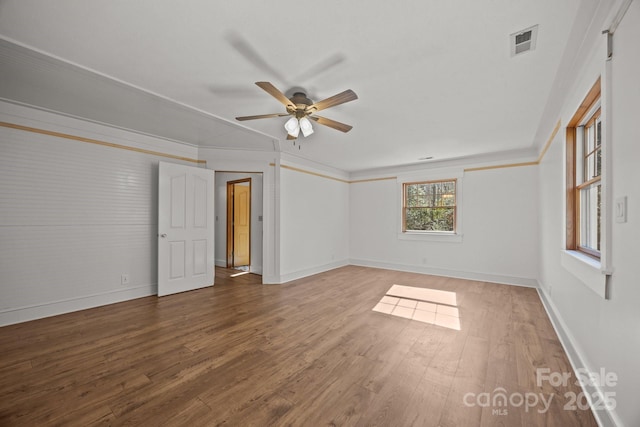 empty room with ceiling fan, crown molding, and hardwood / wood-style floors