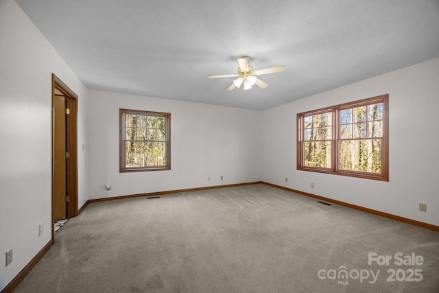 spare room with ceiling fan and light colored carpet