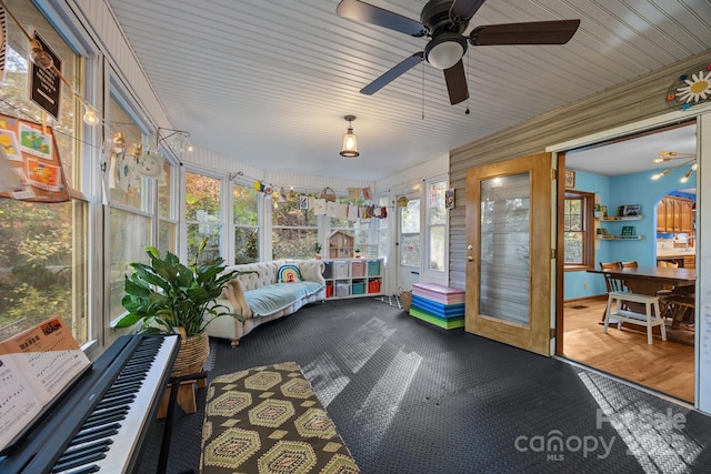 unfurnished sunroom featuring ceiling fan