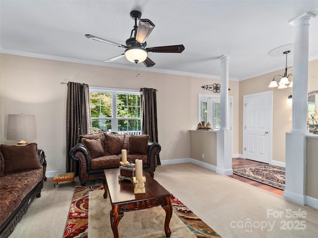 living room with light carpet, ceiling fan with notable chandelier, decorative columns, and crown molding