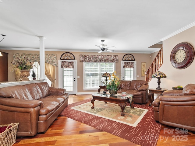 living room with light hardwood / wood-style floors, decorative columns, crown molding, and ceiling fan