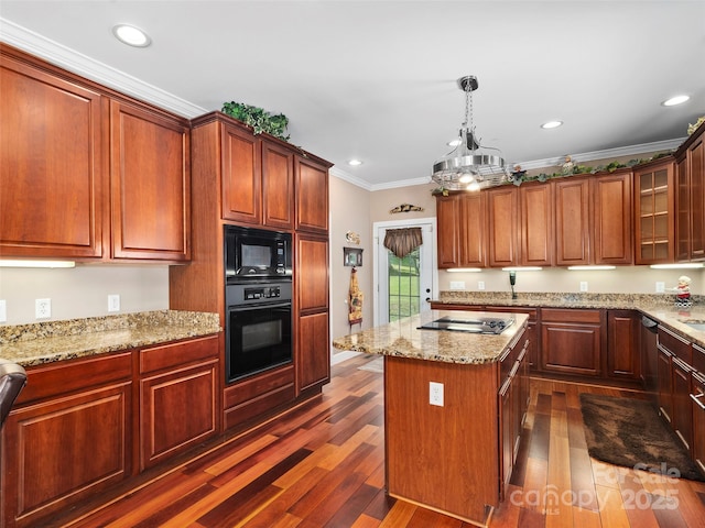 kitchen featuring crown molding, dark wood-type flooring, black appliances, decorative light fixtures, and a kitchen island