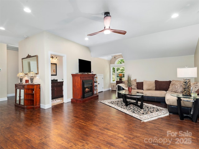 living room featuring ceiling fan, dark hardwood / wood-style flooring, and vaulted ceiling