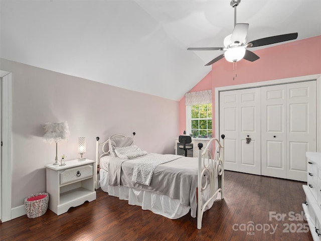 bedroom with ceiling fan, lofted ceiling, dark wood-type flooring, and a closet