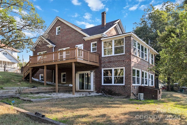 back of house featuring a wooden deck, cooling unit, and a lawn