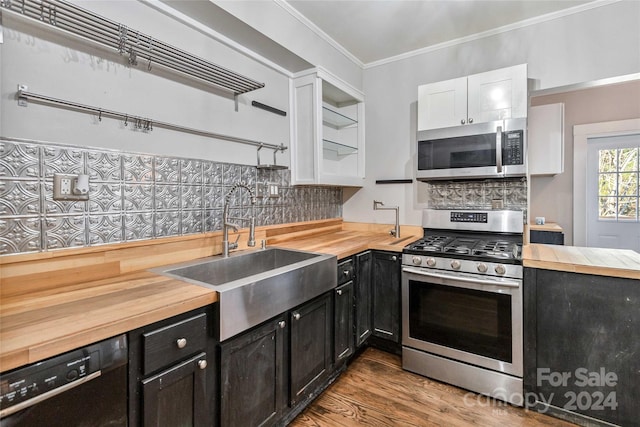 kitchen featuring appliances with stainless steel finishes, butcher block countertops, sink, and white cabinetry