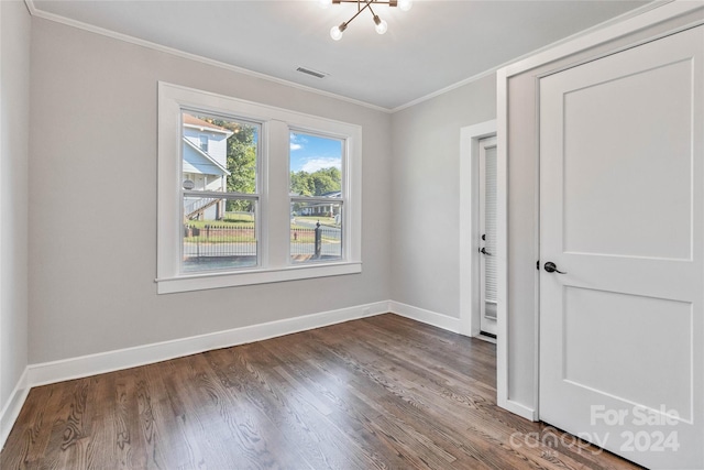 unfurnished room featuring wood-type flooring, a chandelier, and crown molding