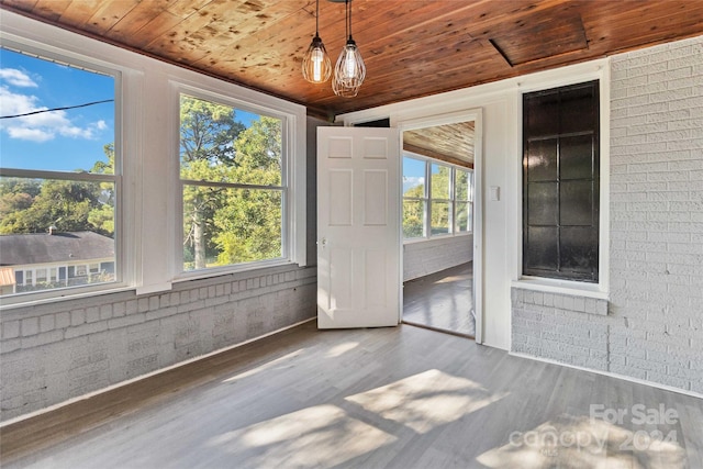 unfurnished sunroom with wood ceiling and an inviting chandelier