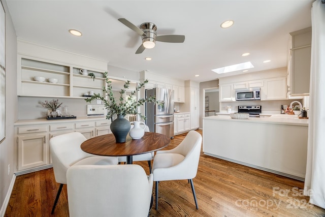 dining room with sink, light hardwood / wood-style flooring, and ceiling fan