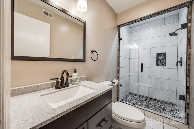 bathroom with toilet, an enclosed shower, and vanity