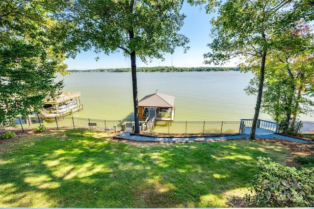 dock area featuring a deck with water view and a lawn