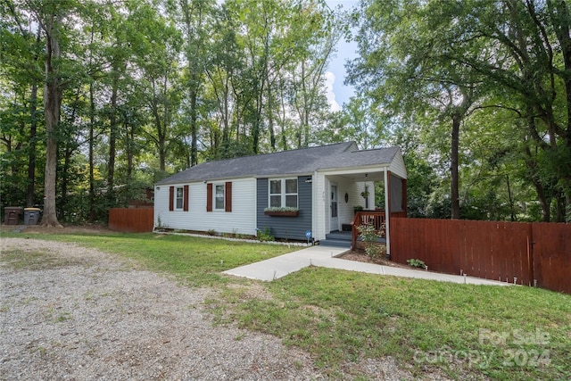 ranch-style house with covered porch and a front yard