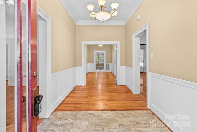 entrance foyer featuring a notable chandelier, light wood-type flooring, and crown molding