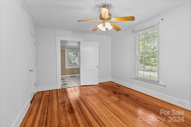 spare room with ceiling fan, crown molding, and light hardwood / wood-style floors