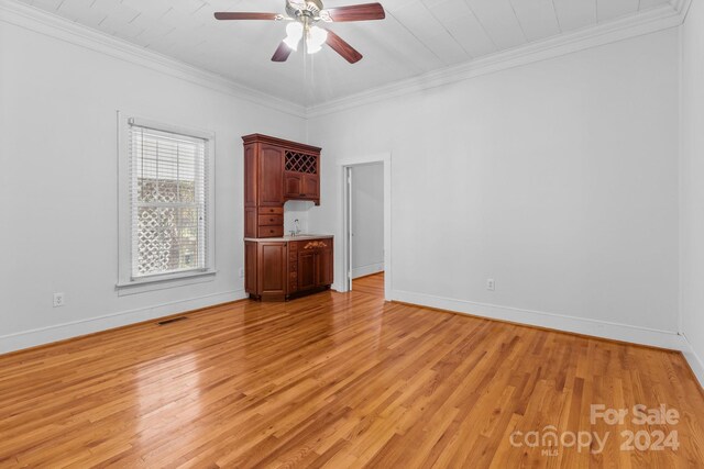 unfurnished living room with ceiling fan, light wood-type flooring, and crown molding