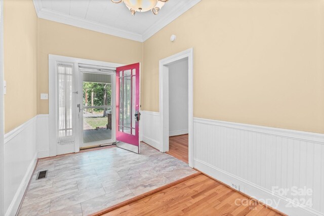 entryway with french doors, crown molding, and light hardwood / wood-style floors