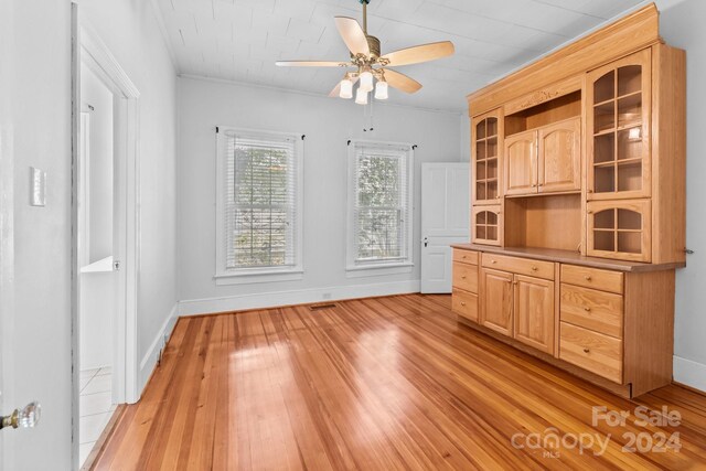 interior space with ceiling fan, light hardwood / wood-style flooring, and ornamental molding