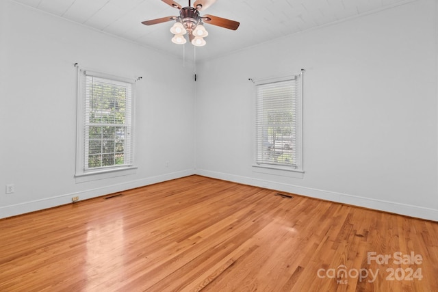 spare room featuring ceiling fan, light hardwood / wood-style floors, and a wealth of natural light