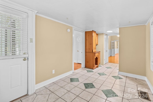 interior space with light tile patterned floors and ornamental molding