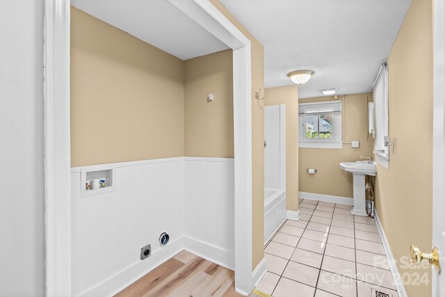 laundry area featuring washer hookup, light tile patterned flooring, sink, and hookup for an electric dryer