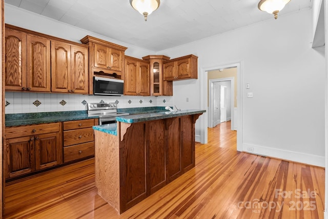 405 7th St, Spencer, NC 28159 - kitchen featuring black microwave, stainless steel electric stove, dark countertops, and backsplash