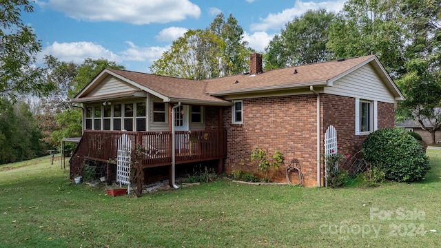 back of house with a deck, a yard, and a sunroom