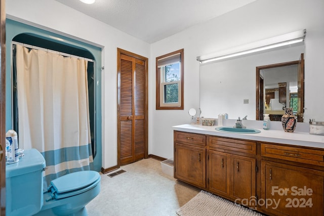 bathroom featuring toilet, a textured ceiling, and vanity