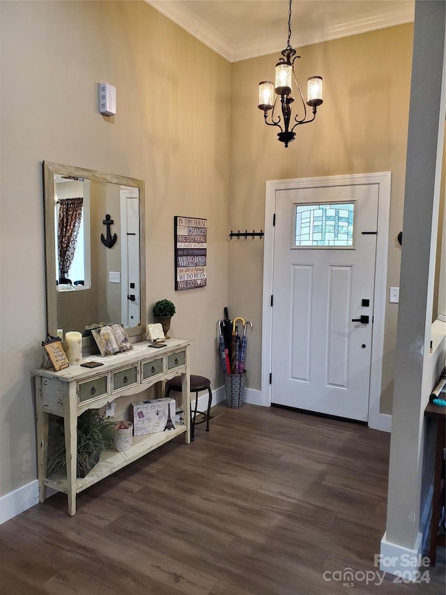 foyer entrance featuring ornamental molding, dark hardwood / wood-style floors, and a notable chandelier