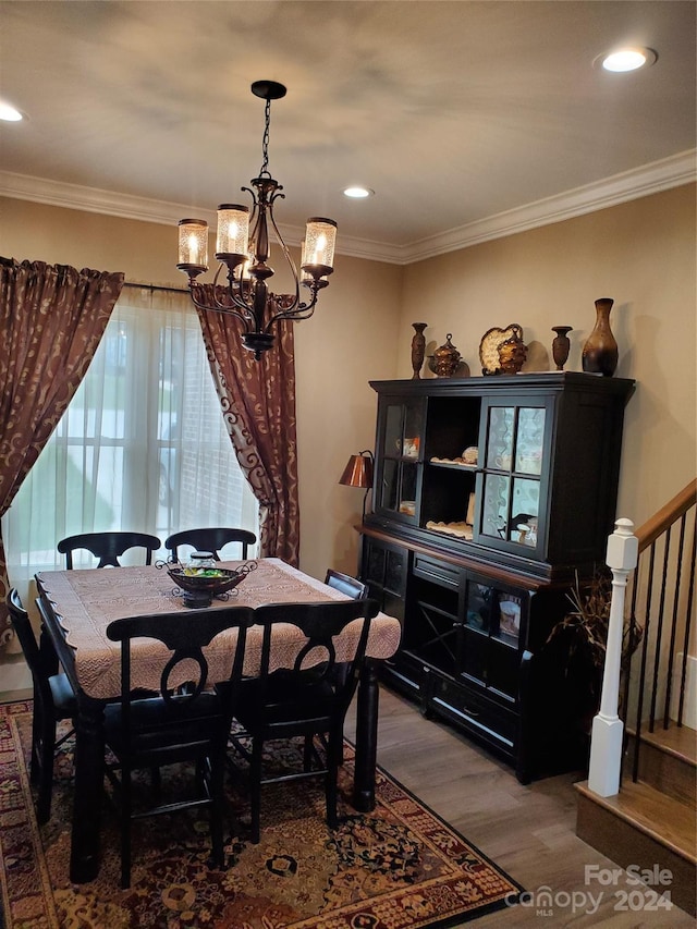 dining room with a notable chandelier, crown molding, and hardwood / wood-style floors