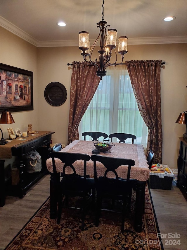 dining area featuring hardwood / wood-style flooring, crown molding, and a chandelier