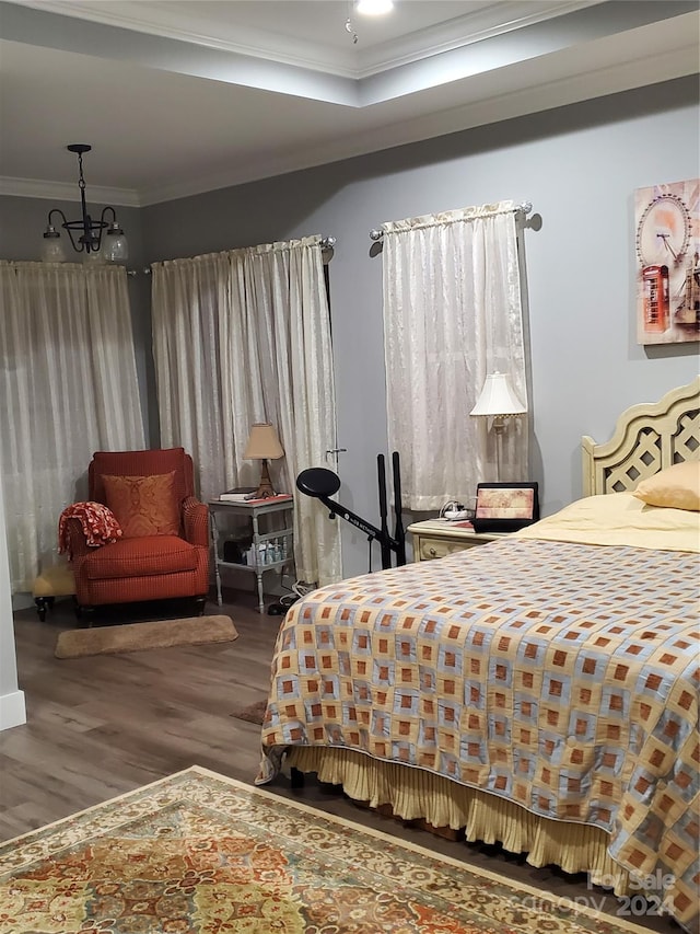 bedroom featuring ornamental molding, a chandelier, and hardwood / wood-style flooring