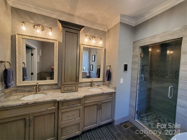 bathroom featuring walk in shower, vanity, crown molding, and tile patterned flooring