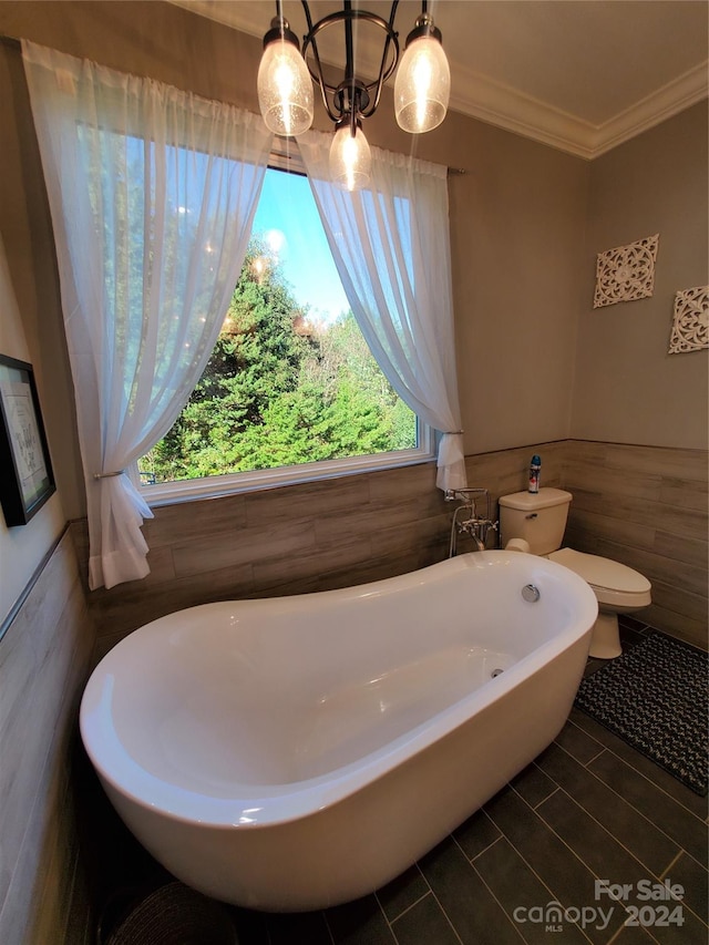 bathroom featuring a bathtub, crown molding, tile walls, and toilet