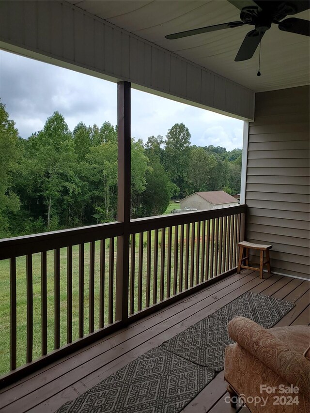 deck featuring ceiling fan and a lawn