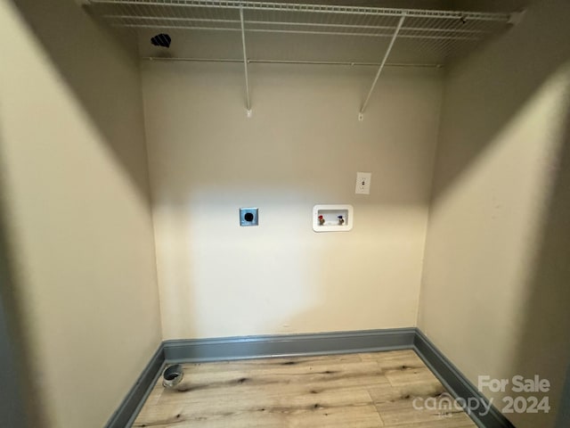 washroom with washer hookup, light hardwood / wood-style floors, and electric dryer hookup