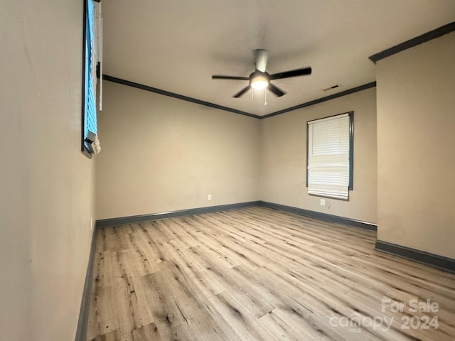 empty room featuring ceiling fan, light wood-type flooring, and ornamental molding