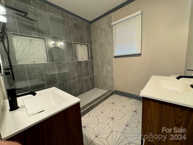 bathroom with a tile shower, ornamental molding, tile patterned floors, and vanity