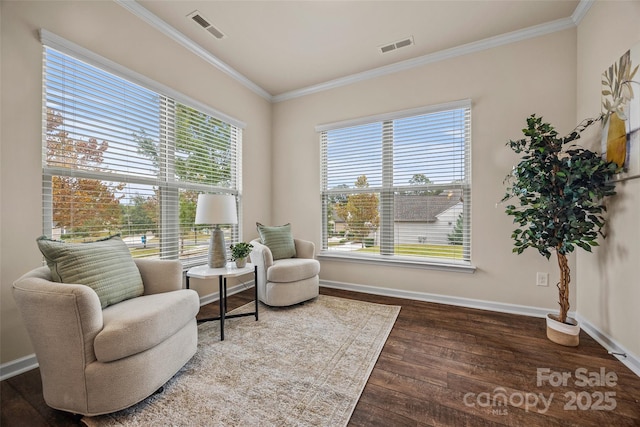 living area with visible vents, crown molding, baseboards, and wood finished floors