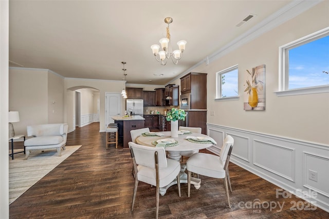 dining room with arched walkways, visible vents, dark wood finished floors, and a notable chandelier