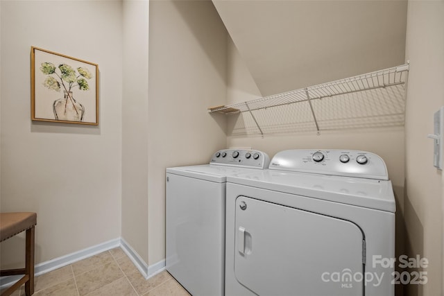 laundry area featuring washer and dryer, baseboards, laundry area, and light tile patterned floors