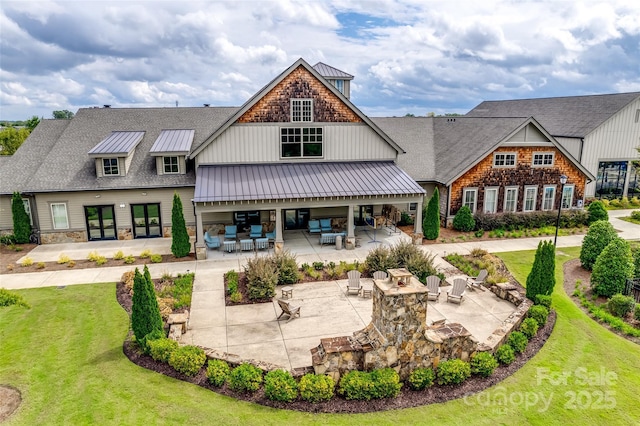 back of house featuring a lawn, metal roof, outdoor lounge area, a patio area, and a standing seam roof