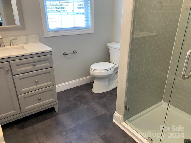 bathroom with vanity, toilet, an enclosed shower, and tile patterned floors