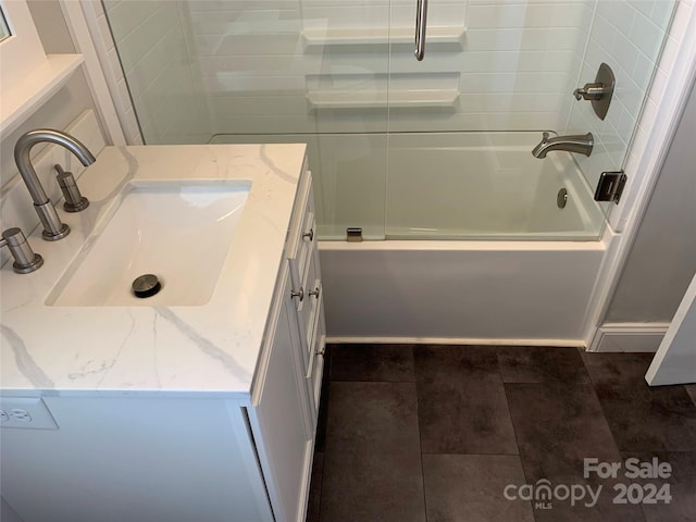 bathroom featuring combined bath / shower with glass door and vanity