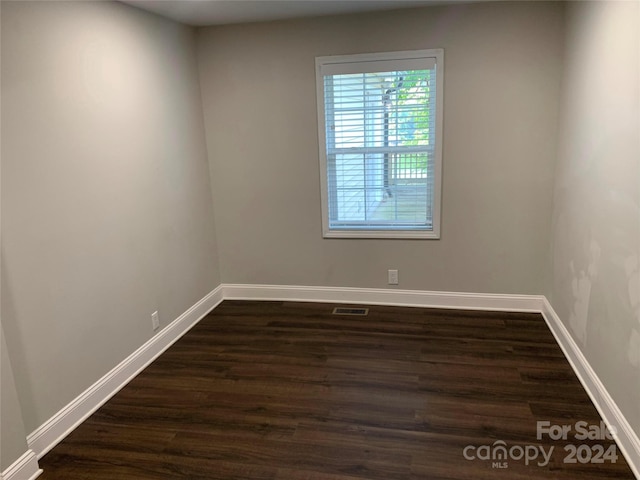 empty room with dark hardwood / wood-style flooring