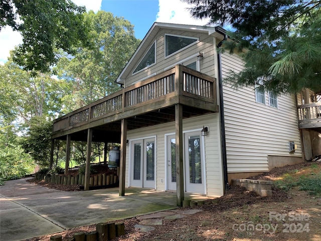 back of property featuring a deck and a patio